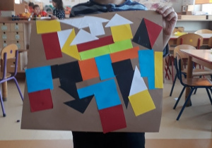 chłopiec prezentuje prace inspirowaną abstrakcją geometryczną