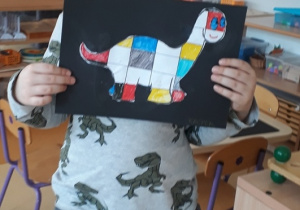 chłopiec prezentuje pracę inspirowaną twórczością Pieta Mondriana